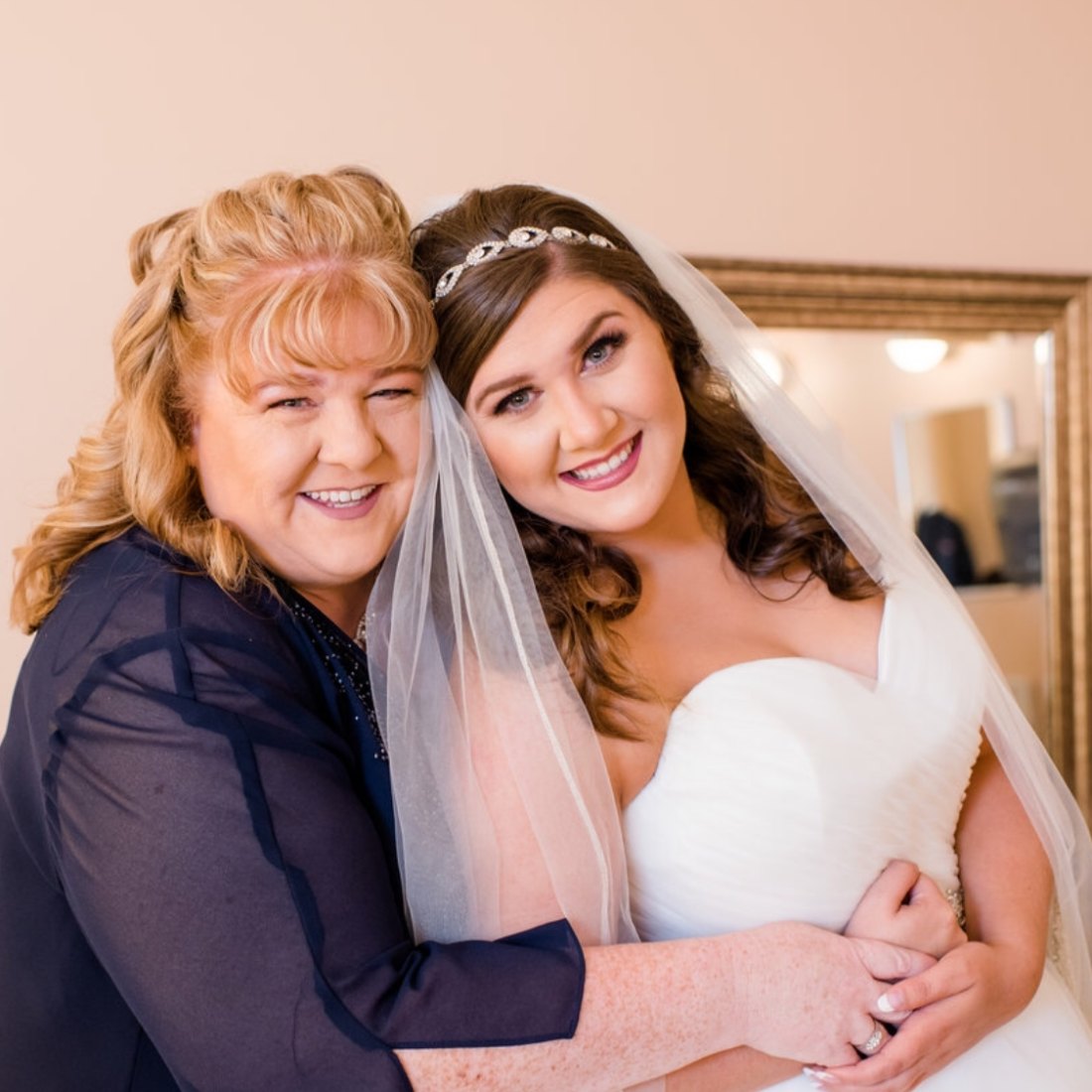 Sherry holding Kimberly on her wedding day, veil and all